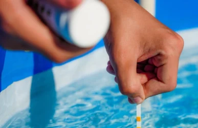 Technician testing pool water during professional maintenance by Commercial Pool Kings.