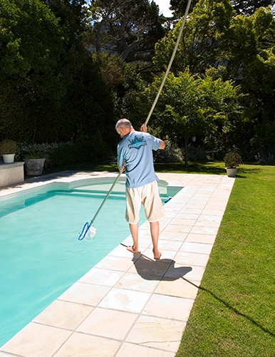 Technician cleaning a commercial pool during professional service by Commercial Pool Kings.